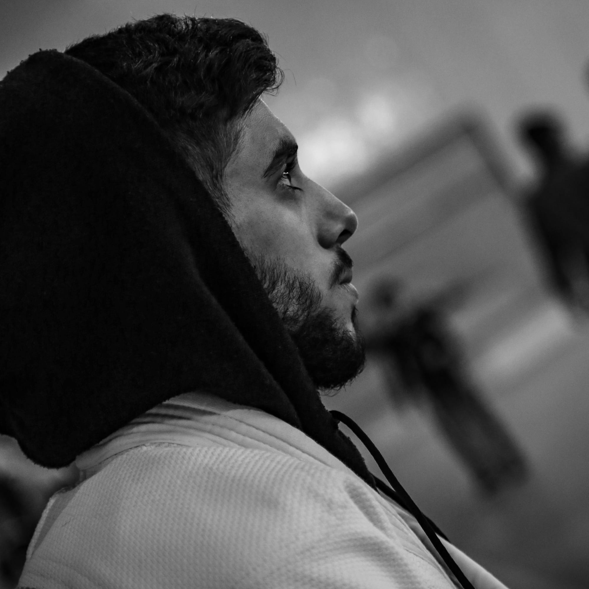 A man in a hoodie looking off into the distance
