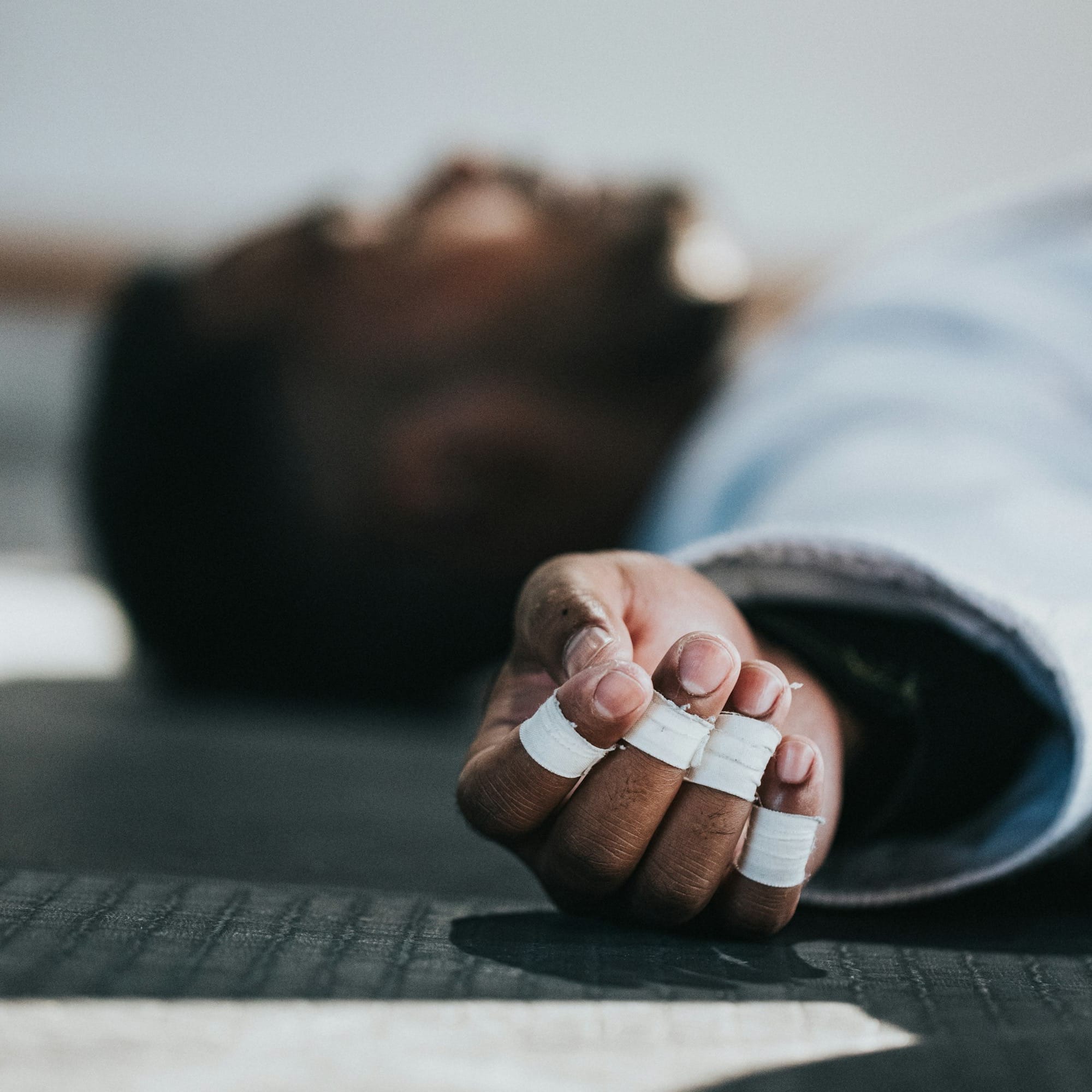 man in blue and white striped long sleeve shirt lying on floor